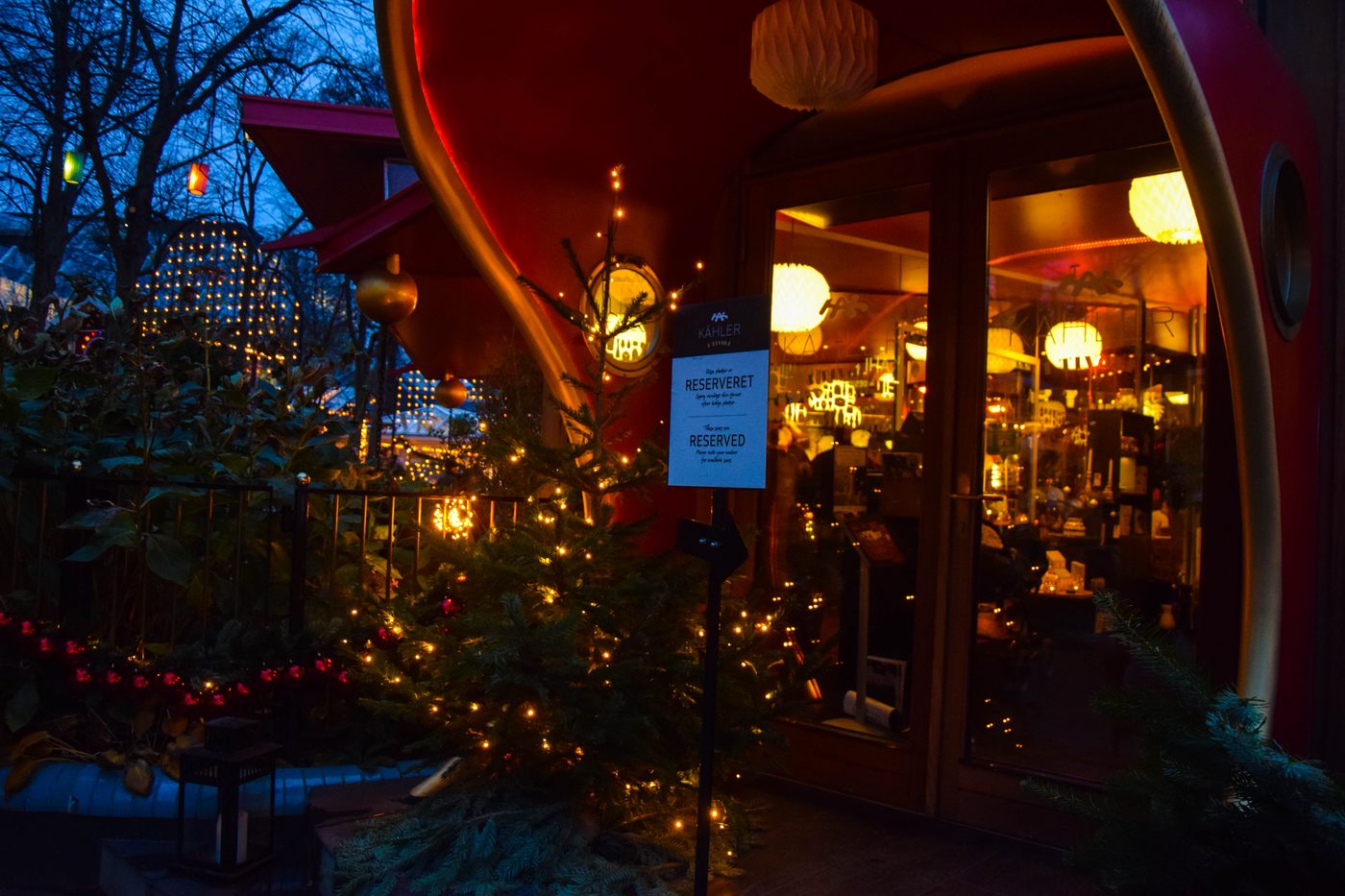 Tivoli Gardens at Christmas — wooden stalls, fairy lights, dark sky, Copenhagen