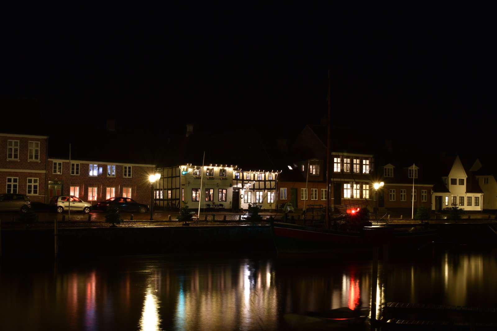 Skibbroen quay at Ribe in the blue hour — old boats and half-timbered houses reflected in the river