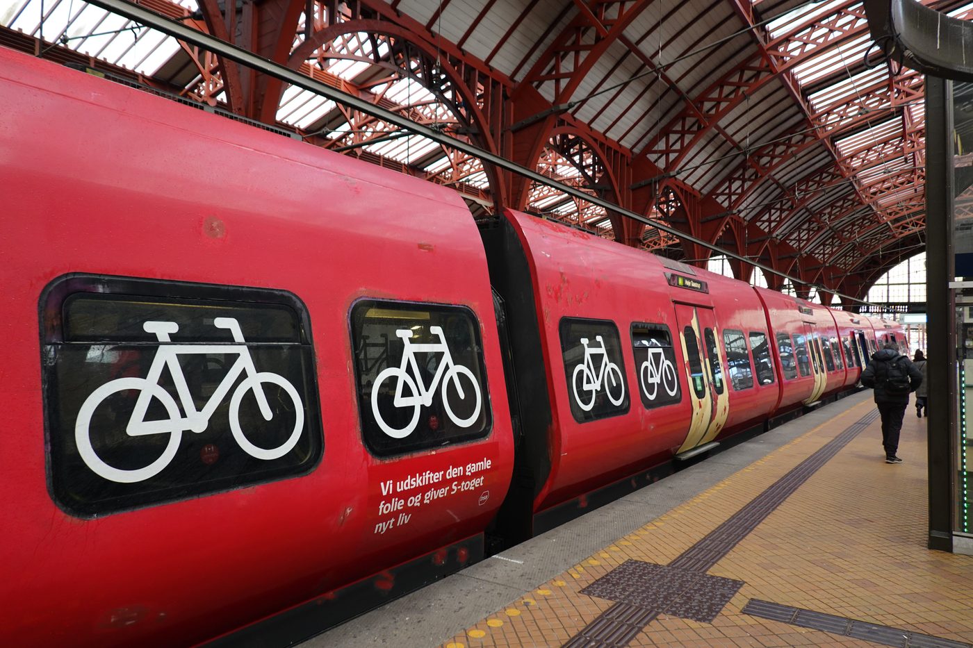 Interior of a Copenhagen S-tog commuter train — bicycles parked, quiet carriage, passengers reading