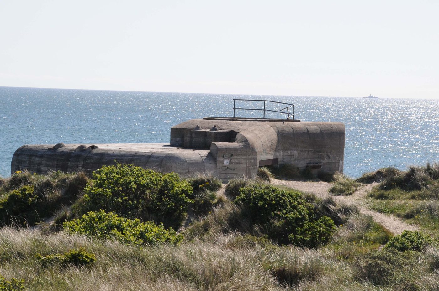 Atlantic Wall bunker remnant on the Danish coast, half-buried in sand